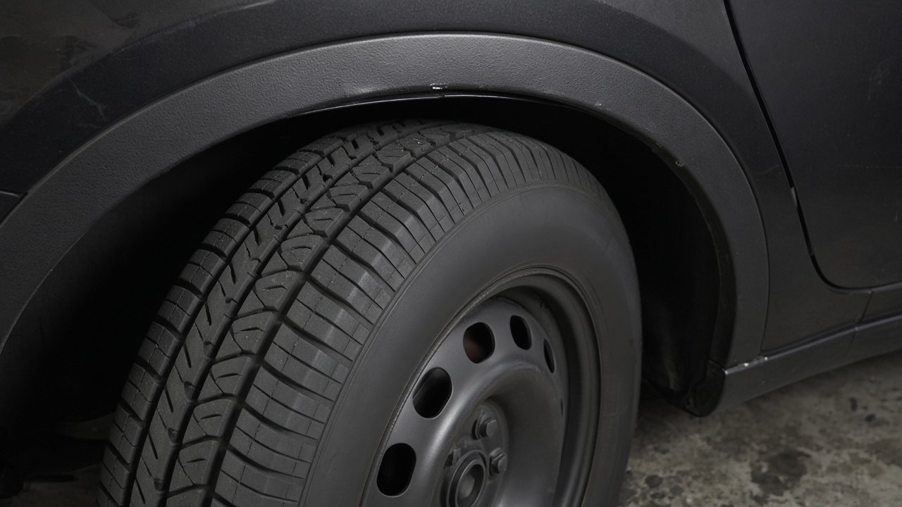 A mounted tire that does not quite clear the wheel well.